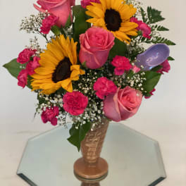 Bouquet of pink roses, sunflowers, and carnations in a vase