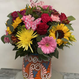Colorful mixed bouquet in a decorated vase with butterfly picks