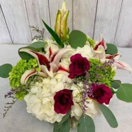 Bouquet of white lilies, red roses, and white hydrangeas with green accents