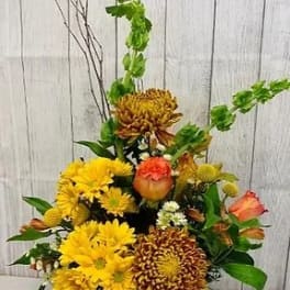 Yellow and orange chrysanthemum arrangement with green accents