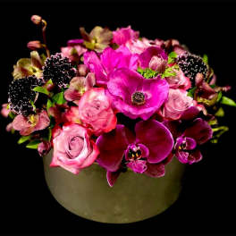 Pink and magenta flowers arranged in a round vase