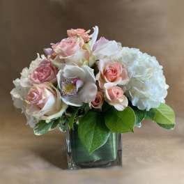 Pink and white roses with hydrangeas in a glass vase