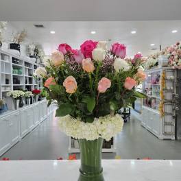 Tall bouquet of pink and white roses in a glass vase