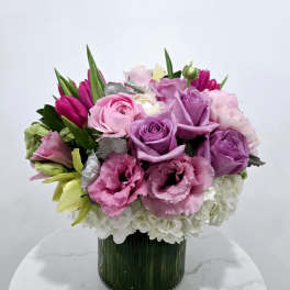 Pink and purple bouquet in a ribbed glass vase