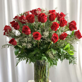 Red roses arranged in a clear glass vase