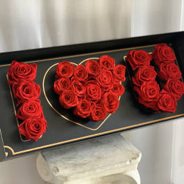 Red roses arranged as the word "I" and a heart in a black box
