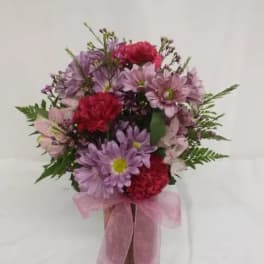 Pink and purple mixed bouquet in a vase with a pink ribbon