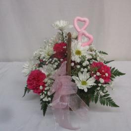 Basket arrangement of white daisies and pink carnations with a pink ribbon bow