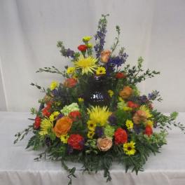 Colorful floral arrangement around a dark vase centerpiece