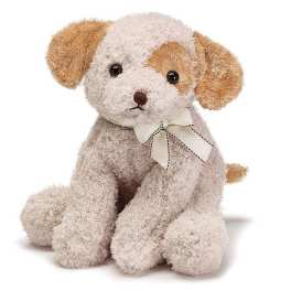 Small cream and tan plush puppy with a ribbon bow around its neck, sitting upright.