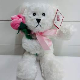 White plush teddy bear holding a pink fabric rose with a pink ribbon and gift tag