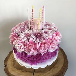 Pink floral cake with striped candles on top