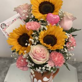 Bouquet of sunflowers, pink roses, and carnations in a patterned vase