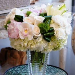 White and blush floral arrangement in a clear glass vase