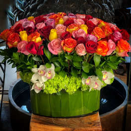 Large arrangement of multicolored roses in a green container