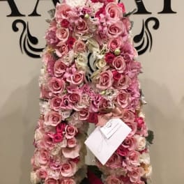 Pink rose and hydrangea floral arrangement shaped like a large letter A