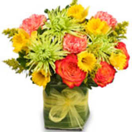 Colorful mixed bouquet in a square glass vase with a ribbon