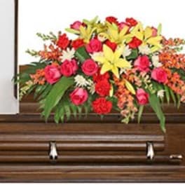 Colorful floral spray arranged on a wooden casket