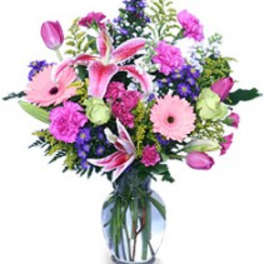 Pink and purple mixed flower bouquet in a clear glass vase
