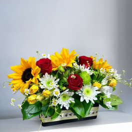 Sunflowers, red roses, and white daisies in a rectangular box