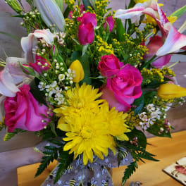 Bouquet of pink roses, yellow chrysanthemums, and white lilies in a vase