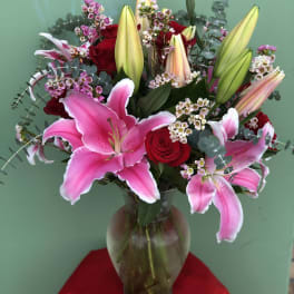 Pink lilies and red roses in a glass vase