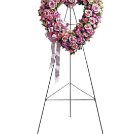 Pink and purple floral standing heart wreath on an easel with ribbon