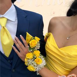 Yellow rose corsage and boutonniere on a couple in formal attire