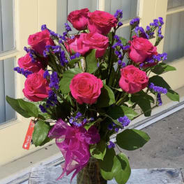 Bouquet of hot pink roses with purple filler in a glass vase