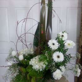 Tall white floral arrangement with gerbera daisies and tulips
