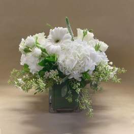 White floral arrangement in a square glass vase