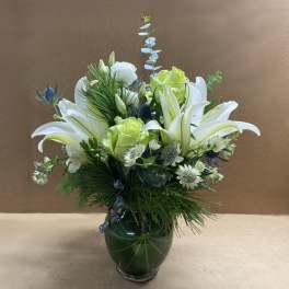 White lilies and pale green roses in a glass vase