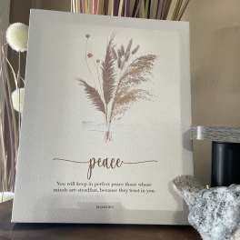 Decorative canvas with dried grasses and the word peace