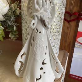 Ceramic angel figurine with cutout details on a shelf