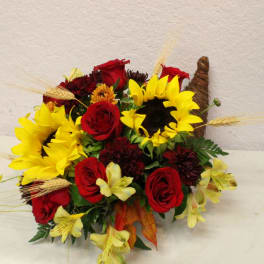 Bouquet of red roses and yellow sunflowers with wheat accents