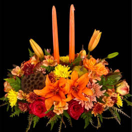 Orange and red floral centerpiece with tall candles