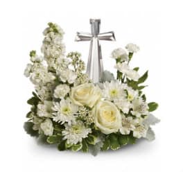 White floral arrangement with a silver cross centerpiece
