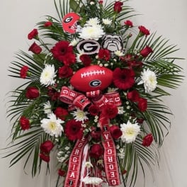 Large red and white floral standing spray with Georgia football decorations
