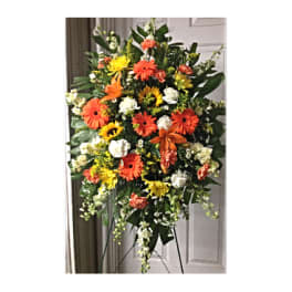 Standing spray of orange, yellow, and white flowers on an easel