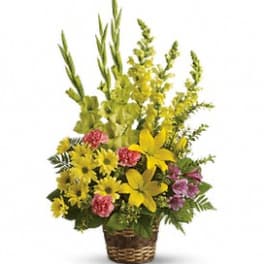 Basket arrangement with yellow and pink flowers