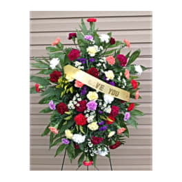 Standing floral spray with multicolored carnations and a ribbon