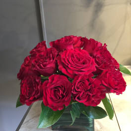 Red roses arranged in a square glass vase