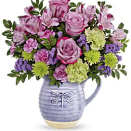 Pink and purple flower arrangement in a lavender ceramic pitcher