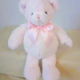 White teddy bear with a pink satin bow