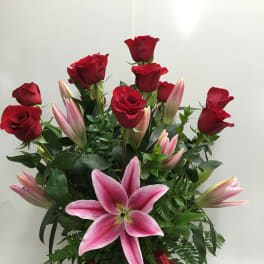 Bouquet of red roses and pink lilies with a red ribbon