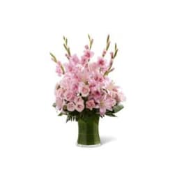 Pink floral arrangement in a green glass vase