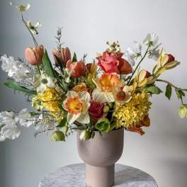 Mixed bouquet in a pink vase with white, yellow, and coral flowers