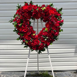 Heart-shaped red rose wreath on a standing easel