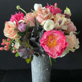 Pink and peach floral bouquet in a tall vase