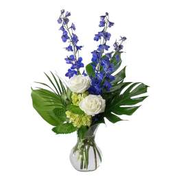 White roses and blue flowers in a glass vase